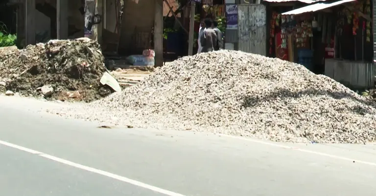 সড়কের পাশে রাখা পাথর বালু